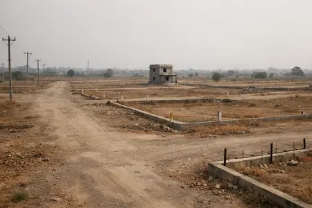 A typical empty residential plot in an undeveloped layout far from the city with no infrastructure illustrating the House Vs Apartment dilemma.
